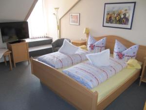 a bedroom with a bed with pillows and a television at Landgasthof-Hotel Zum Anleitner in Rattenberg