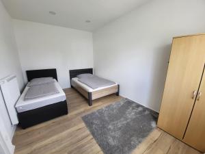 Habitación pequeña con 2 camas y armario. en Wohnung in Crailsheim/Satteldorf, 