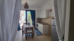 Alba di luna في سانتا تيريزا دي ريفا: مطبخ مع طاولة وكراسي وغرفة طعام