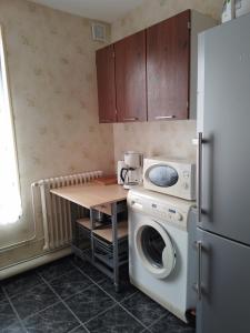 eine Küche mit einem Kühlschrank und einer Waschmaschine in der Unterkunft Résidence ALEXIA in Saint-Valéry-en-Caux