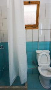 łazienka z białą toaletą i oknem w obiekcie Joana‘s Rooms w mieście Himara
