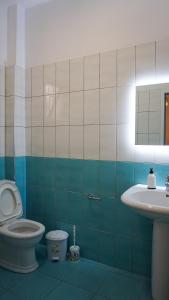 a bathroom with a toilet and a sink at Joana‘s Rooms in Himare