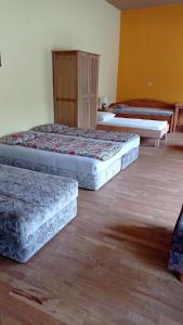 3 camas en una habitación con suelo de madera en Großer Schlafraum in ehemaliger Schule, en Raiding