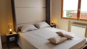 Un dormitorio con una cama blanca con dos almohadas encima. en Casalmare Via Asse, en Ventimiglia