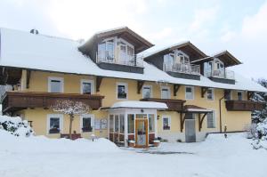 ein großes gelbes Gebäude mit Schnee auf dem Boden in der Unterkunft Landgasthof-Hotel Zum Anleitner in Rattenberg