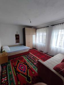 a living room with a bed and a rug at Leppo Guest House in Gacko +14 photos