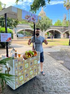 a man standing in front of a box of fruit at Bibike in Catania