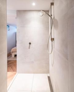 La salle de bains est pourvue d'une douche avec une porte en verre. dans l'établissement Beautyful Amstel houseboat, à Amsterdam