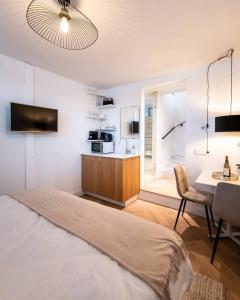 Beautyful Amstel houseboat في أمستردام: غرفة نوم بسرير ومطبخ مع طاولة