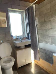 a bathroom with a toilet and a sink and a window at Taigh 24, Barvas in Barvas