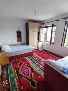 um quarto com duas camas e um tapete no chão em Leppo Guest House em Gacko