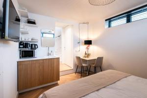 Beautyful Amstel houseboat في أمستردام: غرفة نوم بسرير ومطبخ مع طاولة
