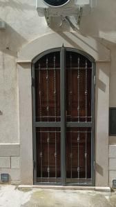 una grande porta in legno con sbarre di metallo su un edificio di dimora arcobaleno a Gioia del Colle