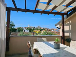 a table on the balcony with a view of the city at Premium Apartments Tade Funtana in Funtana