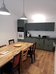 La Chapelle-Basse-MerにあるLa Ferme du domaine de La Mazureの木製のテーブルと椅子のある広いキッチン