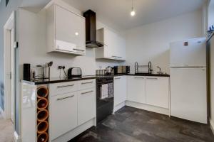 a white kitchen with white cabinets and appliances at The Long Hall 2 bed ground floor annexed apartment - sleeps 6 in Chesterfield