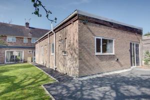 an exterior view of a brick building with a yard at The Long Hall 2 bed ground floor annexed apartment - sleeps 6 in Chesterfield