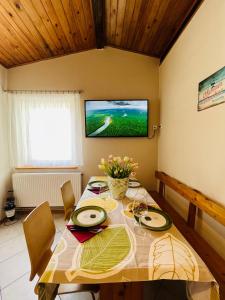 a dining room with a table and a television on the wall at Apartament u Ani 1 in Dźwirzyno