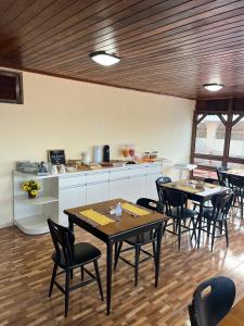 a room with tables and chairs and a kitchen at Pousada Recanto de Ponta Negra in Natal