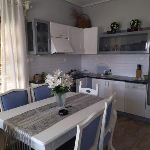 a kitchen with a table with a vase of flowers on it at The Cozy Garden Villa 