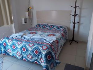 um quarto com uma cama com uma colcha em Quarto Aconchegante em São Bento do Sapucaí