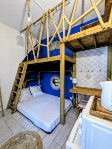 sypialnia z łóżkiem piętrowym i drabiną w obiekcie Au geko bleu w mieście Saint-Pierre