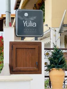a sign on the side of a building with a plant at Yulia Luxury Apartment in Ouranoupoli
