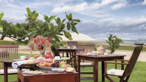 een tafel met eten erop met uitzicht op het strand bij Blue Residence Hotel in Jericoacoara