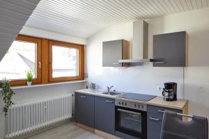 een keuken met een spoelbak en een fornuis bij Ferienwohnung Mendgen mit Panoramablick in Bernkastel-Kues