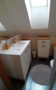 a bathroom with a sink and a skylight at Apartmán AURIS in Veľká Lomnica