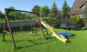 a playground with a slide and a swing set at Apartmán AURIS in Veľká Lomnica