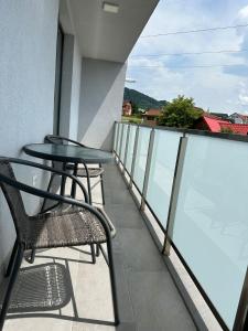 balkon z 2 krzesłami i stołem w budynku w obiekcie Vivo Residence w mieście Baia Mare