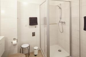 een badkamer met een douche met een glazen deur bij Ferienwohnung Mendgen mit Panoramablick in Bernkastel-Kues +4 foto's