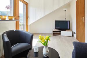 ein Wohnzimmer mit einem Stuhl und einem TV in der Unterkunft Ferienwohnung Mendgen mit Panoramablick in Bernkastel-Kues