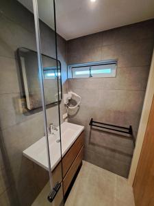 een badkamer met een wastafel en een douche bij B&B De Oase in Bergambacht