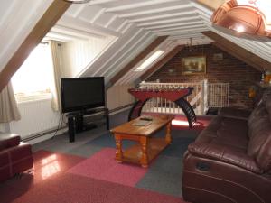 uma sala de estar com um sofá e uma televisão em The Barn, Norwich em Norwich