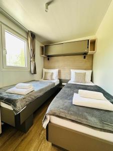 1 dormitorio con 2 camas y ventana en Brand New Mobile House - Soline Beach, en Biograd na Moru