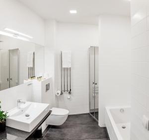 La salle de bains blanche est pourvue de toilettes et d'un lavabo. dans l'établissement Apple Inn, à Varsovie