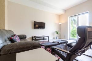 a living room with a couch and a tv at Our boutique Fort Lauderdale guest house in Fort Lauderdale
