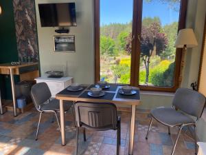 a dining room with a table and chairs and a window at Dom na skarpie in Płaska