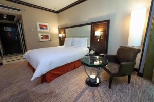 une chambre d'hôtel avec un lit, une table et une chaise dans l'établissement Holiday Inn Kuwait Al Thuraya City, an IHG Hotel, à Koweït
