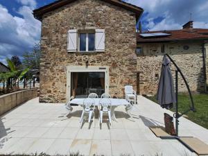 Latouille-LentillacにあるMaison COUNORD - Gite pour 8 personnesの建物の前にパティオ(テーブル、椅子付)