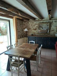 Latouille-LentillacにあるMaison COUNORD - Gite pour 8 personnesの木製のテーブルと椅子のあるダイニングルーム