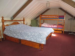 ein Schlafzimmer mit einem Bett, einem Etagenbett und einem Stuhl in der Unterkunft The Barn, Norwich in Norwich