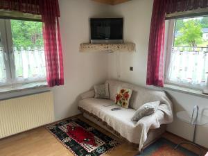 ein Wohnzimmer mit einem Sofa und einem Flachbild-TV in der Unterkunft Haus Berchtold in Hermagor