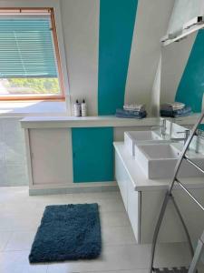 uma casa de banho com 2 lavatórios e uma parede azul em Maison Juliette em Lembeke