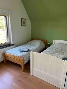 Lembeke的住宿－Maison Juliette，一间卧室设有两张床和窗户。