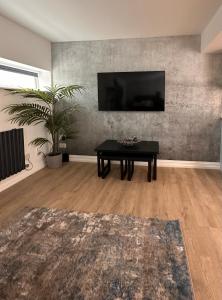 ein Wohnzimmer mit einem Tisch und einem Flachbildfernseher in der Unterkunft The Cottage in Saint Annes on the Sea