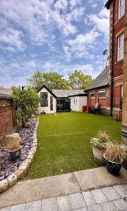 a yard of a house with a lawn with plants at The Cottage in Saint Annes on the Sea