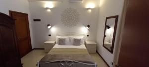 Un dormitorio con una cama con almohadas y un espejo. en Dimora di Acanto - Lecce, en Lecce